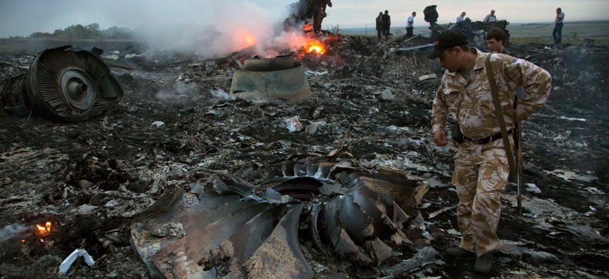 People walk among the debris of the plane after the crash Thursday.