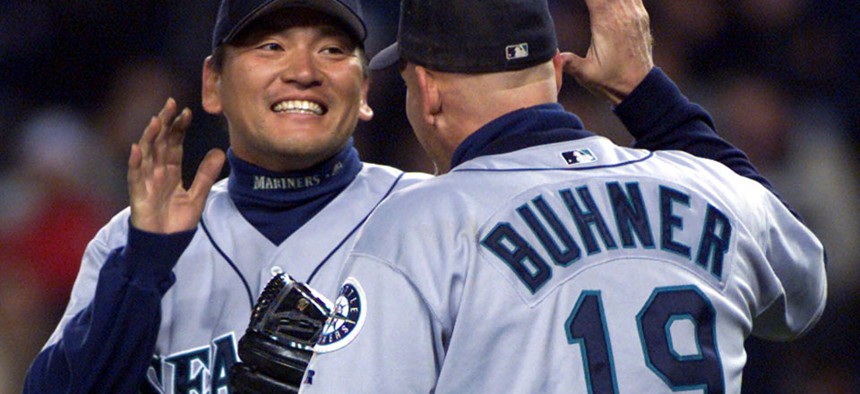 Seattle Mariners relief pitcher Kazuhiro Sasaki celebrates with right fielder Jay Buhner after defeating the New York Yankees.