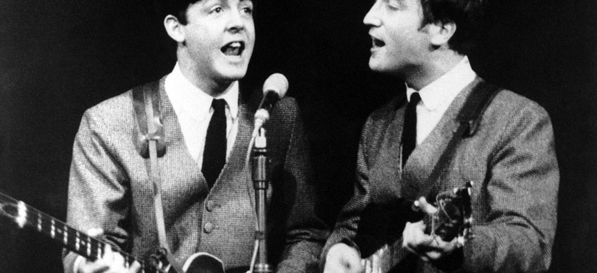 Paul McCartney, left, and John Lennon perform in London, on Nov. 11, 1963.