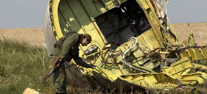 A pro-Russian rebel touches the MH17 wreckage Tuesday.