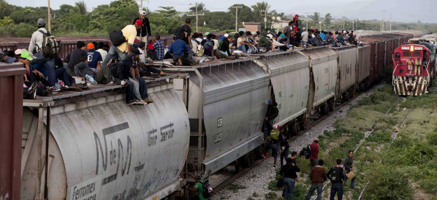 Central American migrants ride a freight train during their journey toward the U.S.-Mexico border in Ixtepec, Mexico.