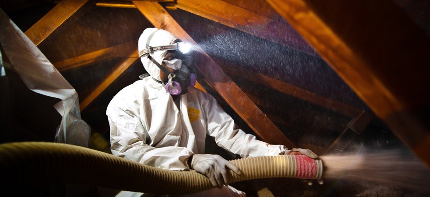 A man blows cellulose insulation in the attic of a Colorado home as part of the Energy Department's Weatherization Assistance Program.
