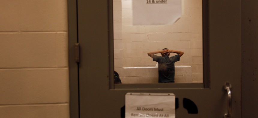 A teenage immigrant who was detained at the border is held inside Texas' McAllen Border Patrol Station July 15.