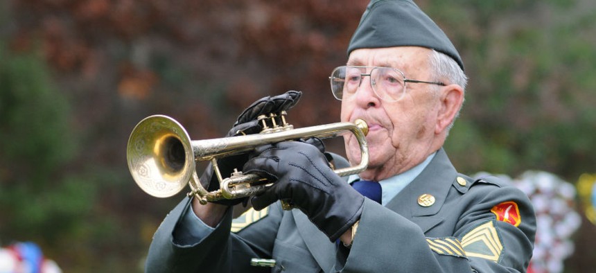 A World War II veteran plays taps at the Massachusetts National Cemetery in Bourne. 