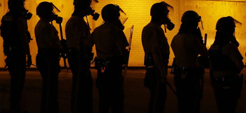 Police prepare to advance after using tear gas to disperse protesters in Ferguson, Mo. 