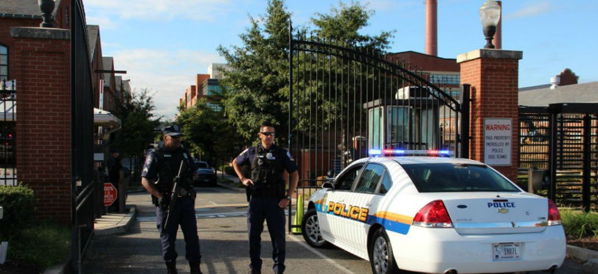 Guards watch the entrance of the Washington Navy Yard, where last year's shooting by contractor Aaron Alexis has prompted questions about the security clearance process. 