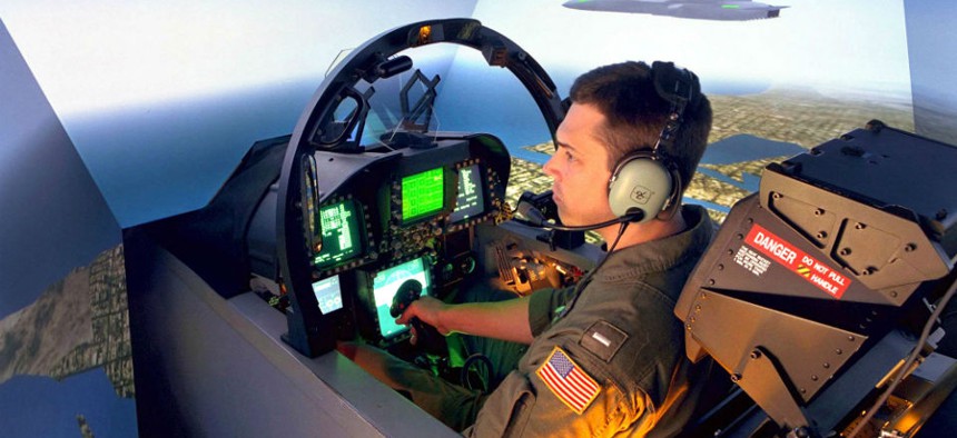 A Navy F/A-18 pilot at Naval Air Station LeMoore, California, trains in 2005 in a simulator built and maintained by industry. 