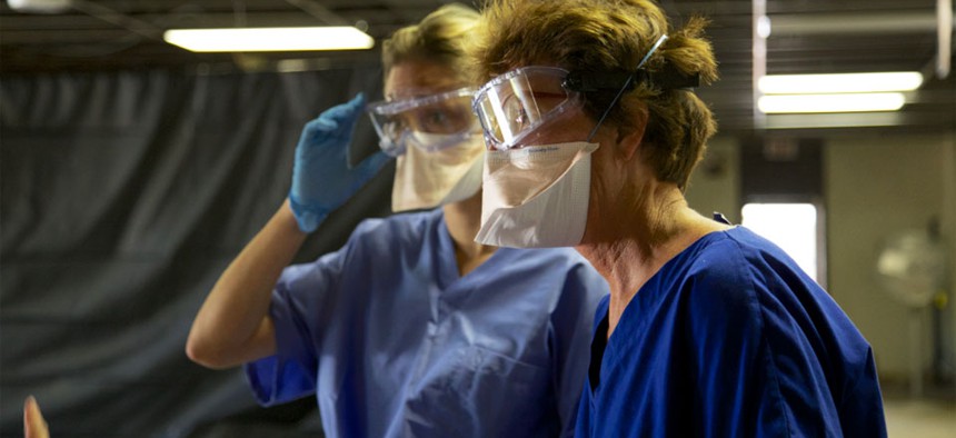 Health care workers learn the proper protocols for personal protective equipment during a CDC Ebola training course. 