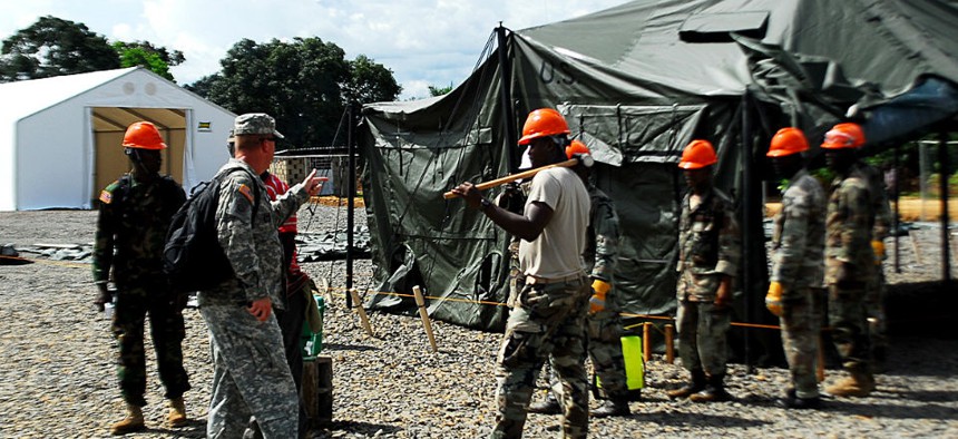 Troops help build an Ebola treatment center in Liberia.  Military members must go into quarantine when they leave West Africa. 