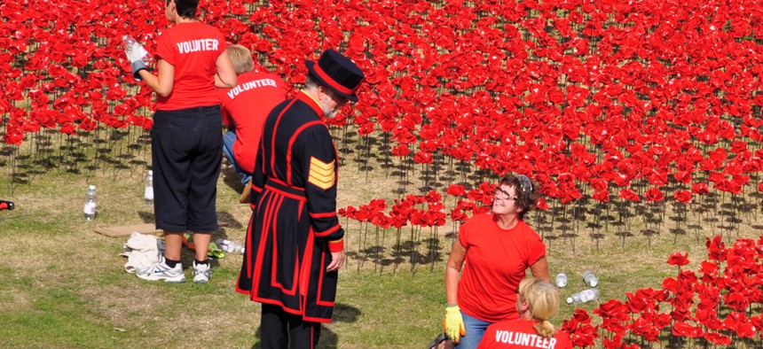 A yeoman and volunteers installing 888,246 ceramic poppies on August 7, 2014 commemorate the First World War British and colonial military fatalities.