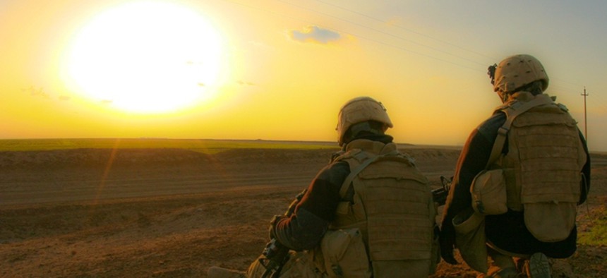 U.S. Marines take a break to watch the sunset after a dismounted patrol in Iraq in 2009.