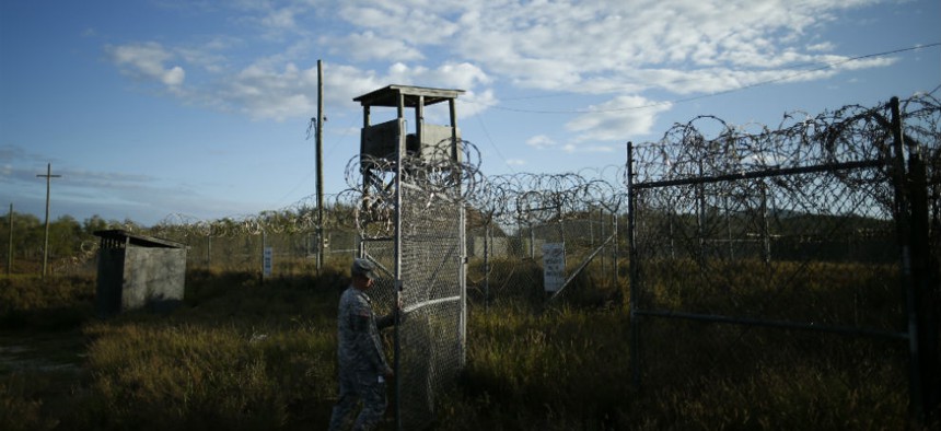 A soldier closes the gate at the now abandoned Camp X-Ray at Guantanamo in 2013.
