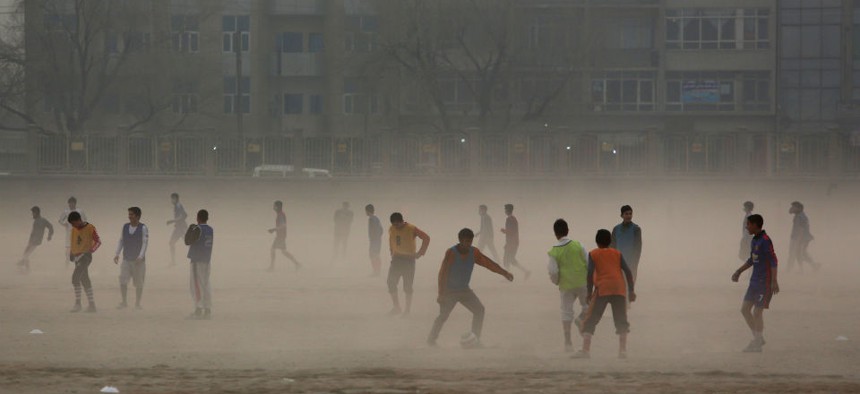 Afghan boys play football in the city of Kabul, Afghanistan, Monday, Dec. 29, 2014.