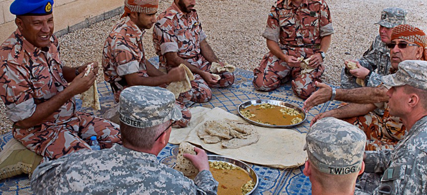 U.S. linguists share a meal with Omanis and British Foreign Service Officers in 2012.