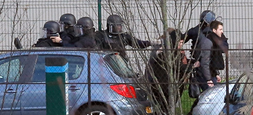 Police officers arrive at the hostage situation at a kosher market in Paris Friday.