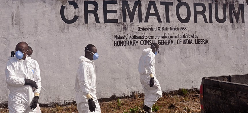 Health workers prepare to collect the ashes of people that died due to the Ebola virus at a crematorium near Monrovia, Liberia.
