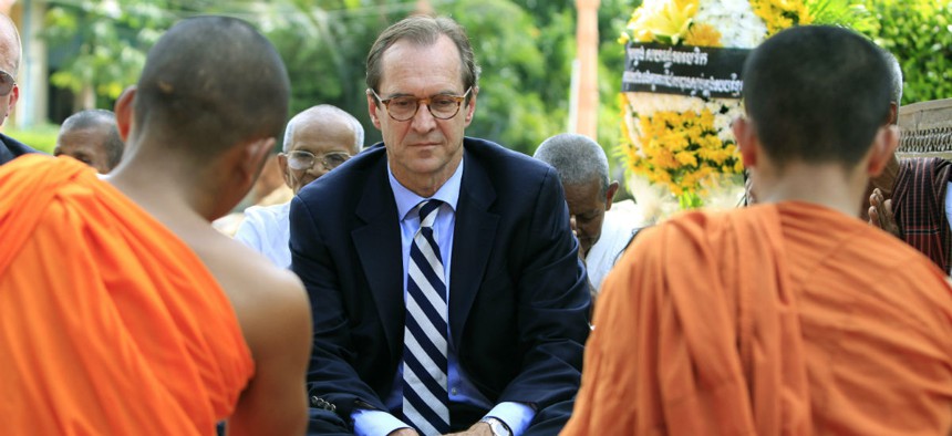 David Ensor, center, director of the Voice of America, listens to Cambodian Buddhist monks near Phnom Penh, Cambodia, in 2012.