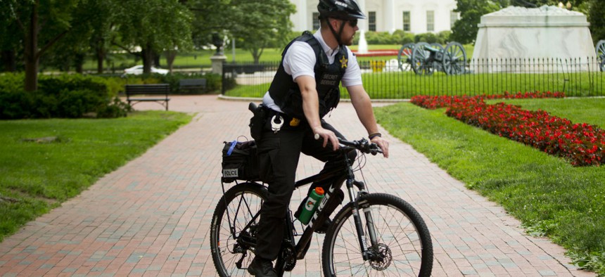 A Secret Service officer patrols Lafayette Park across from the White House on Tuesday. 