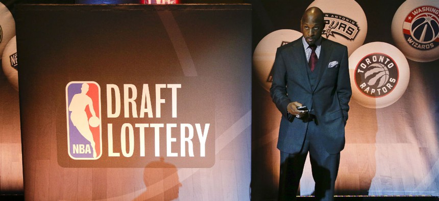 Miami Heat VP Alonzo Mourning checks his cellphone before the NBA draft lottery in May.