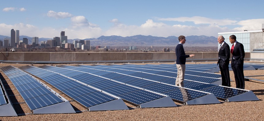 Obama and Biden speak with a solar company official in 2009 amongst solar panels.