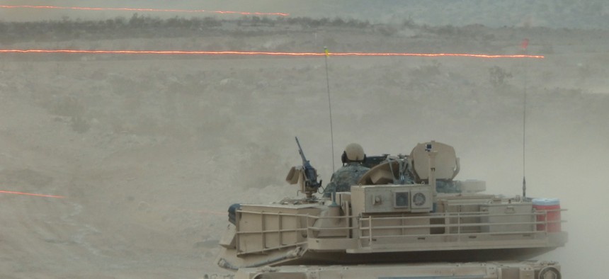 Tracer fire whizzes by an Army Abrams tank during a Joint Forcible Entry Exercise on Aug. 5.