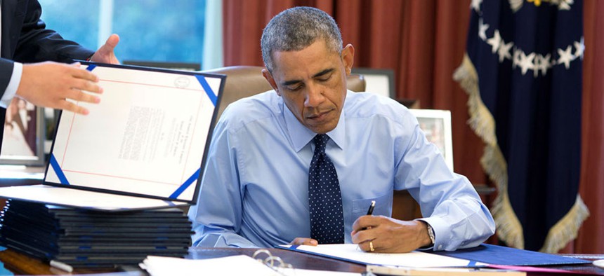 President Obama signs bills in the Oval Office in September 2014. 