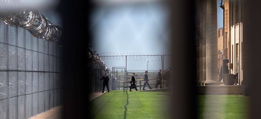 White House staff walk into Oklahoma's  El Reno Federal Correctional Institution in July.