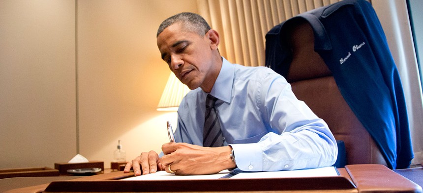 Barack Obama signs two presidential memoranda associated with his actions on immigration in his office on Air Force One in 2014.