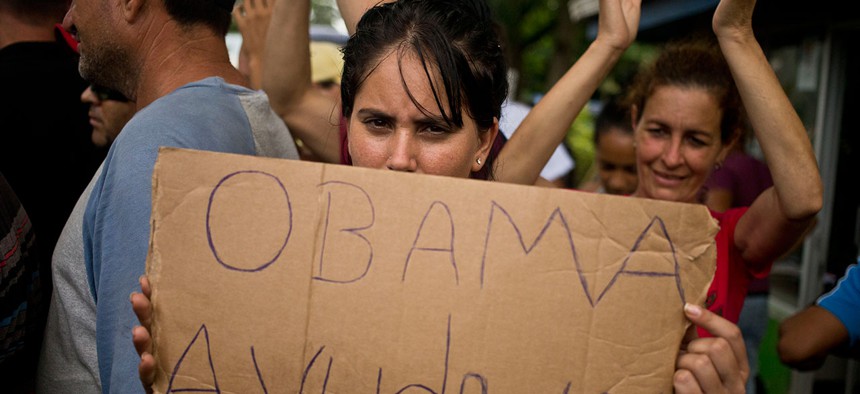 A Cuban migrant holds a sign that reads in Spanish "Help us Obama" during a protest at the Costa Rican border with Nicaragua on Monday.