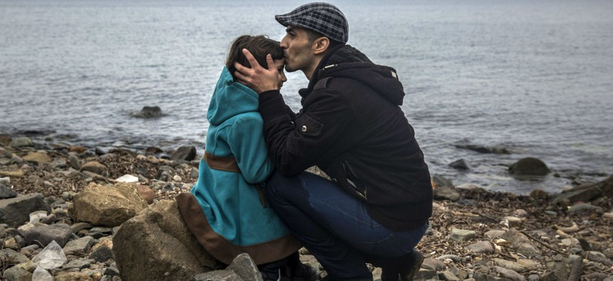 A Syrian man and his daughter reach the beach on the Greek island of Lesbos after crossing the Aegean sea from the Turkish coast in a dinghy. 