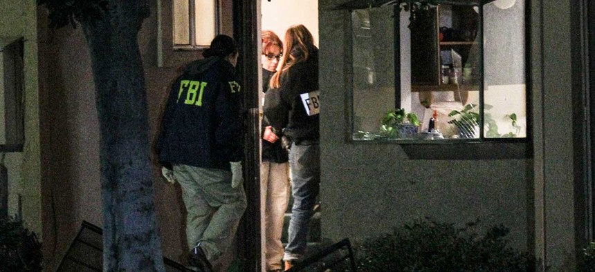 Agents search a home in connection to the shootings in San Bernardino Thursday.