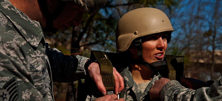 Air Force Staff Sgt. Christine Phillips has her parachute harness tightened during a training exercise in 2013.