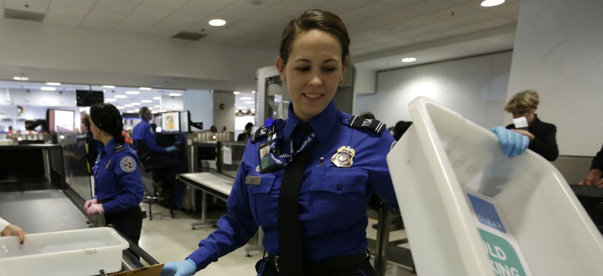 A TSA agent screens items in Miami over the Thanksgiving holiday. 