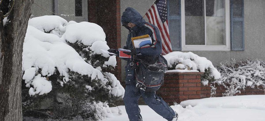 Postal worker Van Nguyen walks through the snow as he delivers the mail in Denver in 2013.