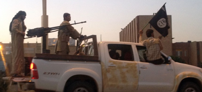 Islamic State militants parade in a commandeered Iraqi security forces vehicle in Mosul in 2014.