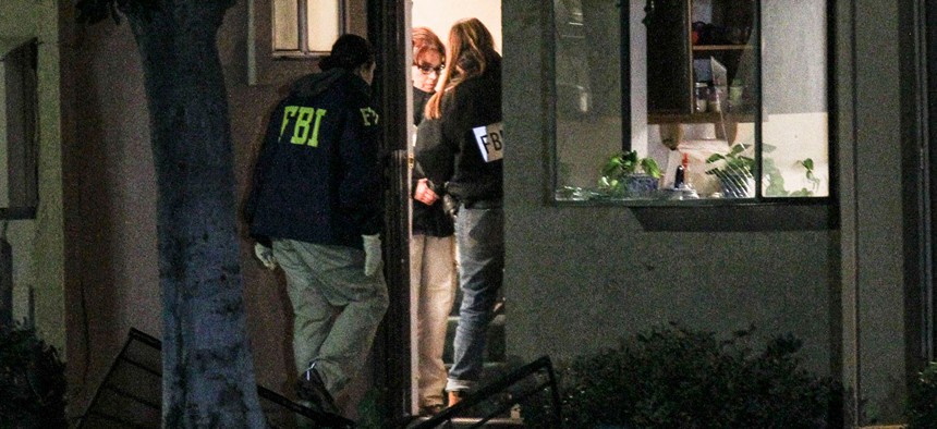 FBI agents search near a house in connection with the December shooting.