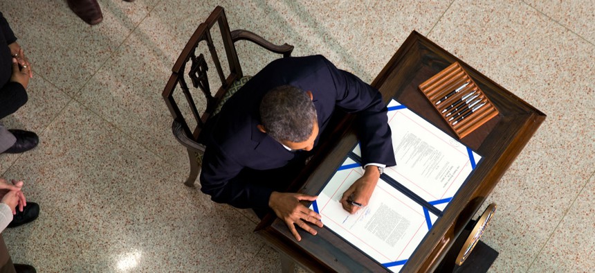 Obama signs a bill in 2014 in the New Executive Office Building.