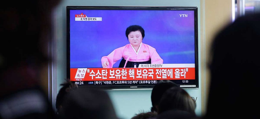 People watch a TV news program showing North Korea's announcement, at the Seoul Railway Station in Seoul Wednesday.