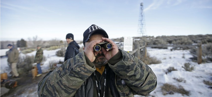 Sean Anderson, of Idaho, a supporter of the group occupying the Malheur National Wildlife Refuge, looks through binoculars at the front gate Jan. 6.