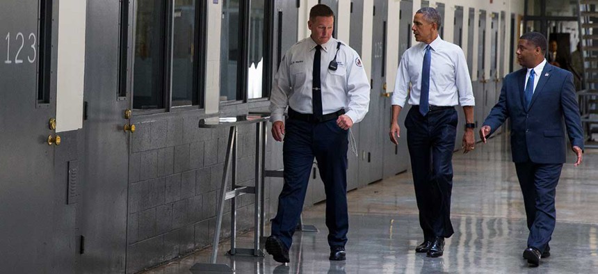 Barack Obama is led on a tour by Bureau of Prisons Director Charles Samuels, right, and correctional officer Ronald Warlick during a visit to Oklahoma's El Reno Federal Correctional Institution in July.