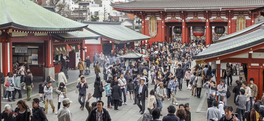 A crowd of Japanese people walk near a Buddhist temple in Tokyo in 2012.