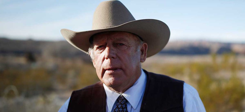 Rancher Cliven Bundy stands along the road near his ranch in January after his son was arrested.
