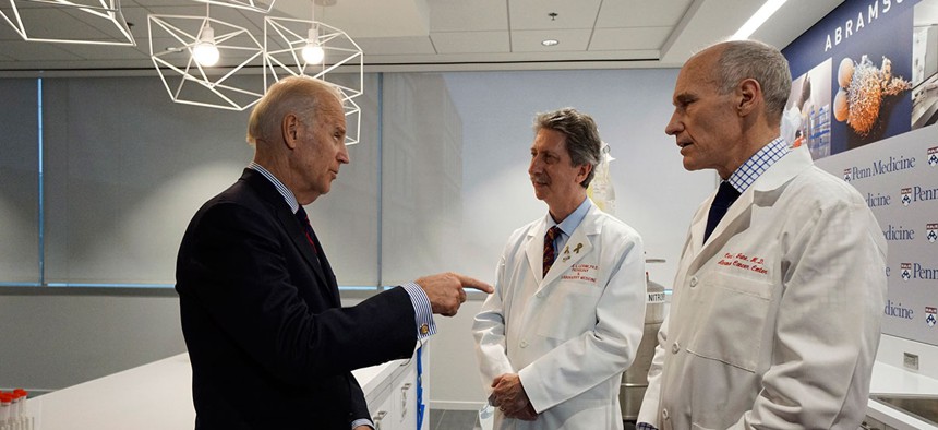  Joe Biden, left, gestures while speaking with Dr. Bruce L. Levine PH.D., center, and Dr. Carl H. June M.D., in the Abramson Cancer Center at the University of Pennsylvania in January.