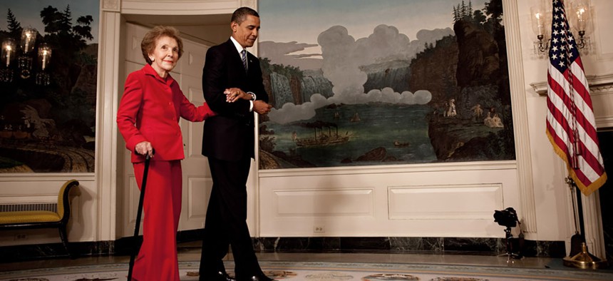 Obama escorts former First Lady Nancy Reagan in the Diplomatic Room of the White House in 2009.