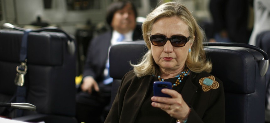Hillary Clinton checks her Blackberry aboard a C-17 military plane in October 2011. 