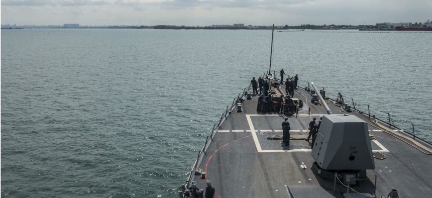 The USS Mustin arrives in Singapore for a scheduled port visit.  The contractor admitted to $1.6 million in fraudulent charges for one of the destroyer's port visits. 