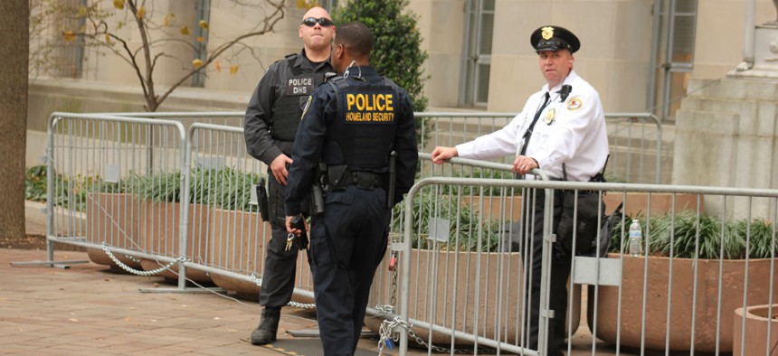 Security officers stand outside the Justice Department during a rally. 