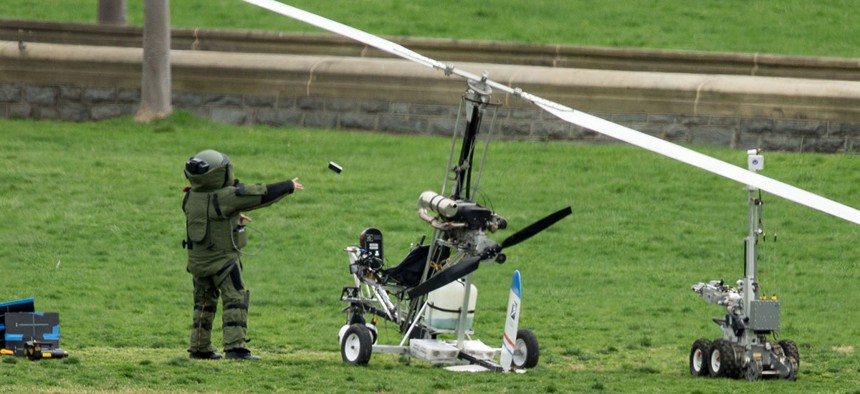 A member of a bomb squad examines the felled gyrocopter after it crashed in April 2015.