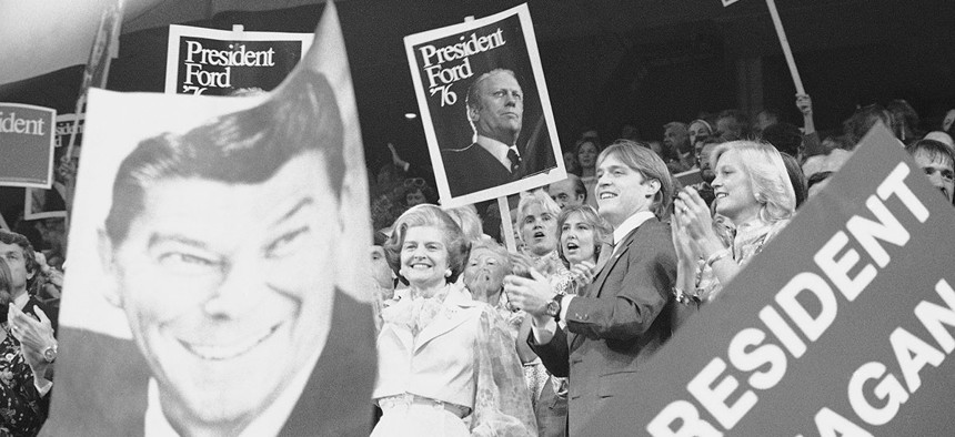 First Lady Betty Ford, left, stands surrounded by signs supporting Pres. Gerald Ford and Ronald Regan at the nominating session of the 1976 GOP convention.