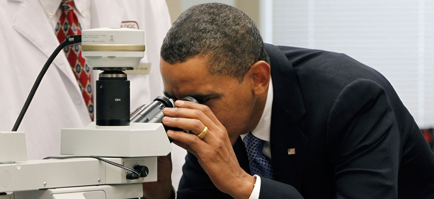 Obama looks through an NIH microscope in 2009.